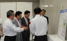 ポスターセッション会場で大河内理事長から説明を受ける松井知事と浅田議長